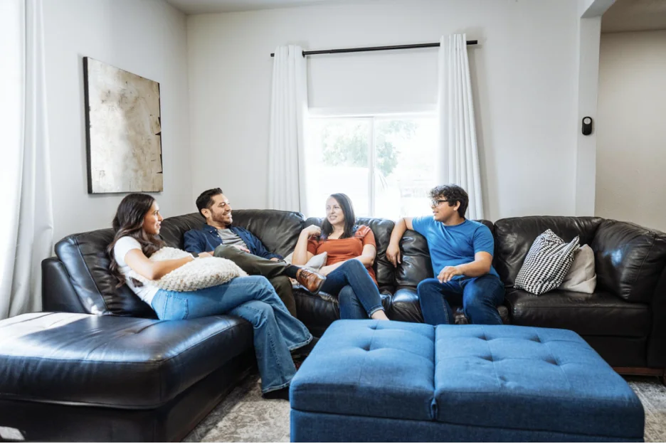 Familia hispana sentada en su sala revisando opciones de seguro con tranquilidad